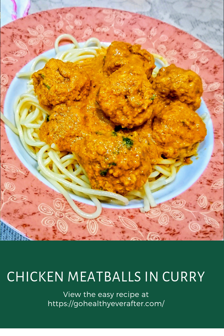 close-up view of chicken meatballs in curry sauce on spagetti